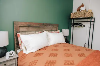 a bedroom with an orange bed with green walls at Dundas and Brock Suitel in Toronto