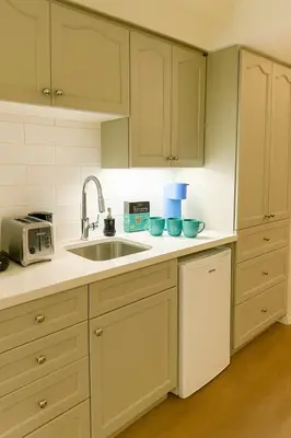 a kitchen with white cabinets and a sink at King Bed Suite with Pool and Hot Tub Access in Shanty Bay