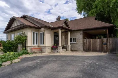 a house with a wooden fence and a driveway at 4 Bedroom Stoney Creek Nature Oasis Sauna, Games & Luxury Comfort in Hamilton