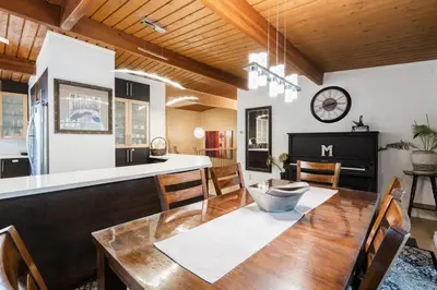 a kitchen and dining room with a wooden table at 4 Bedroom Stoney Creek Nature Oasis Sauna, Games & Luxury Comfort in Hamilton