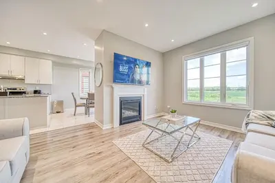a living room with a couch and a fireplace at Spacious 3BR Townhome Near Casino & Thermea Spa in Ajax