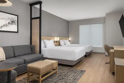 a hotel room with a bed and a couch at Hyatt Place Toronto Airport in Toronto