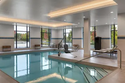 a swimming pool with a table and chairs in a building at Hyatt Place Toronto Airport in Toronto