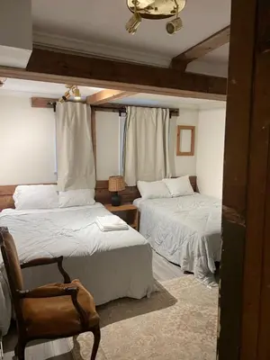 a bedroom with two beds and a chair in it at Carlton House in Toronto