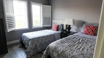 a bedroom with two beds and two windows at Spacious 5br Home W Parking In Mississauga in Mississauga