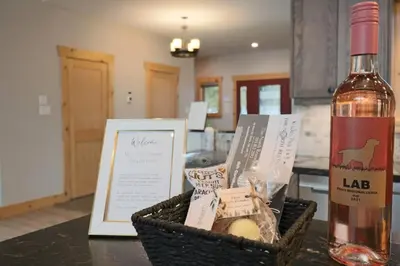 a bottle of wine sitting next to a basket of food at Waterfront 3 Bedroom Home in Port McNicoll