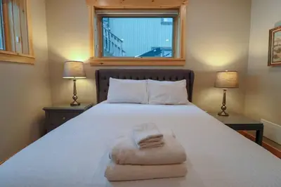 a bedroom with a large white bed with two lamps at Waterfront 3 Bedroom Home in Port McNicoll
