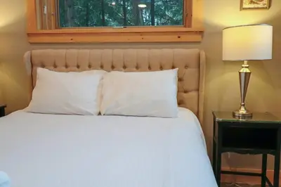 a bedroom with a bed with a lamp and a window at Waterfront 3 Bedroom Home in Port McNicoll