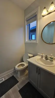 a bathroom with a toilet and a sink and a mirror at Grand Woodstock Luxe House 4BR in Woodstock