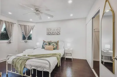 a white bedroom with a bed and a ceiling fan at Luxe 4BR Retreat w Heated Pool Hot Tub and BBQ in Whitby