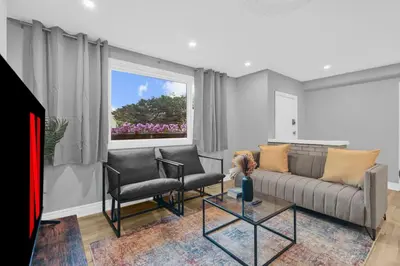 a living room with a couch and chairs and a window at Stylish 3 BR Apt with Free Parking, Wifi and Patio in Whitby