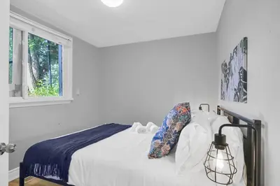 a white bedroom with a bed and a window at Stylish 3 BR Apt with Free Parking, Wifi and Patio in Whitby
