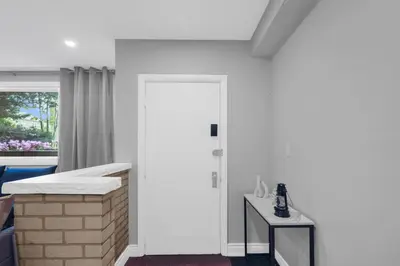 a white room with a bed and a window at Stylish 3 BR Apt with Free Parking, Wifi and Patio in Whitby