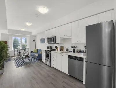 a kitchen with white cabinets and a stainless steel refrigerator at Stylish 1BR Condo in Prime Location with Parking and Wi Fi in Kitchener