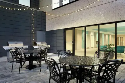 a patio with tables and chairs and a grill at Home2 Suites by Hilton Milton Ontario in Milton