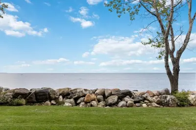 a pile of rocks next to the ocean at Serene Waterfront Escape On Private Lane in Thornbury