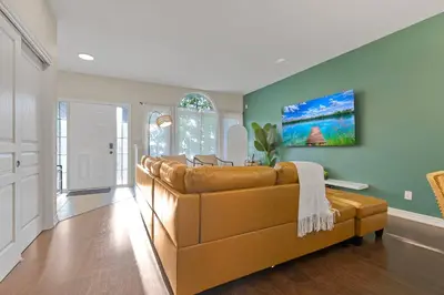 a living room with a brown leather couch and green walls at Niagara Retreat|HotTub|Sauna|Games|15 Min to Falls in Thorold