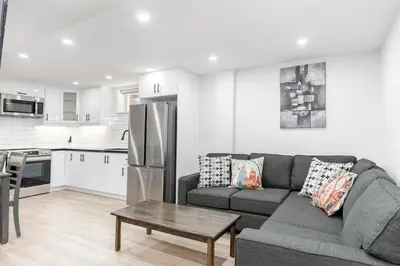 a living room with a couch and a kitchen at Cozy 3BR 2 Bath Lower Level Close to Shops in Richmond Hill
