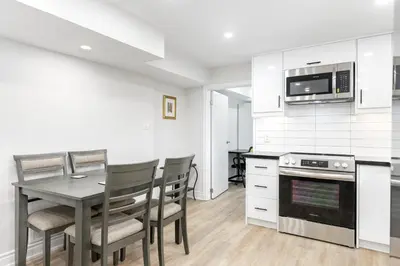 a kitchen with a table and chairs and a microwave at Cozy 3BR 2 Bath Lower Level Close to Shops in Richmond Hill