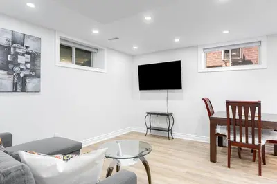 a living room with a couch and a tv on a wall at Cozy 1BR Lower Level Walking distance to shops in Richmond Hill