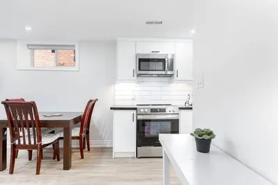 a kitchen with a table and a stove and microwave at Cozy 1BR Lower Level Walking distance to shops in Richmond Hill