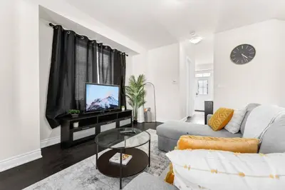a living room with a couch and a tv at Joyful Haven|KingBed|Air Hockey| 10 mins to Falls in Thorold