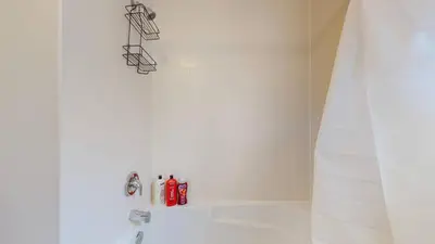 a white bathroom with a white tub and a shower at Joyful Haven|KingBed|Air Hockey| 10 mins to Falls in Thorold