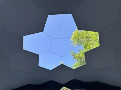 a blue and white wall with a tree in the background at Rare Mirrored Glamping Dome in Severn