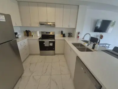 a kitchen with a sink and a stove top oven at Stylish 3BR 2.5 Bath Townhouse with Patio and parking in Mississauga