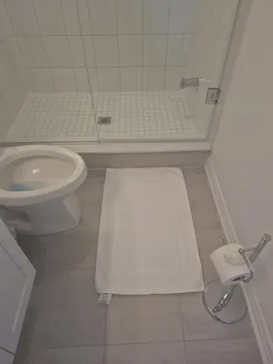 a bathroom with a toilet and a white rug at Stylish 3BR 2.5 Bath Townhouse with Patio and parking in Mississauga