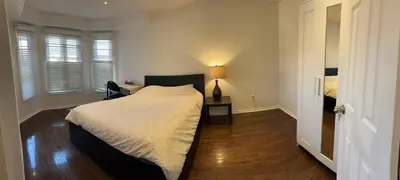 a bedroom with a bed and a table with a lamp at Private comfortable M1 bedroom in Mississauga
