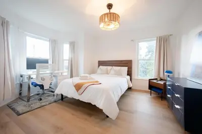 a white bedroom with a bed and a desk at County Cove - Newly Renovated Century Home in Carrying Place