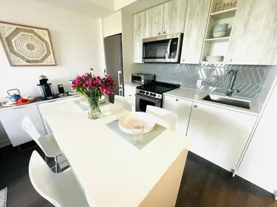 a kitchen with white cabinets and a white counter top at Lakeview in Toronto