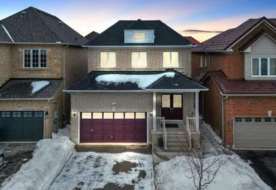 a house with a red garage door in the snow at Stylish Modern 2-bedroom Basement Suite in Brampton
