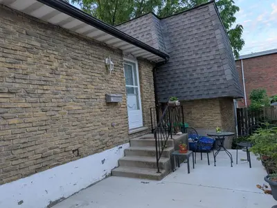 a brick house with stairs and a table and chairs at Cozy home away from home, close to hospital, college, and university with free parking in Peterborough
