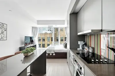 a kitchen with a large window and a bedroom at Modern Studio Retreat in Downtown Toronto in Toronto