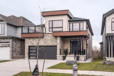 a large house with a garage in front of it at The Simple Escape, Walkout Basement on Ravine in Kitchener