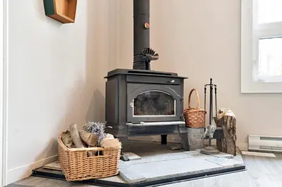 a fireplace in a living room with wicker baskets at Muskoka Waterfront Cottage with Canoes and Fire Pit in Huntsville