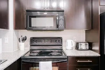 a kitchen with a stove and a microwave at Elegant 2BR 2BA Condo Heart of Mississauga SQ1 in Mississauga
