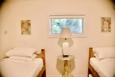 two twin beds in a room with a window at Serendipity 5 BR Waterfront 4 Seasons, Hot Tub, Firepit, Close to Ski HIll in Haliburton