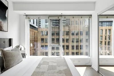 a bedroom with a large window with a view of a building at Trendy 1BR in TO Steps to Entertainment & Dining in Toronto