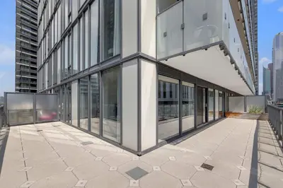 a building with glass windows on the side of it at Prime 2BR Condo with Massive Patio & Parking in Toronto