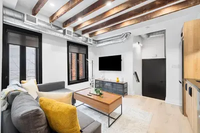 a living room with a couch and a tv at Modern Parkdale Getaway 1-Bedroom Parking in Toronto