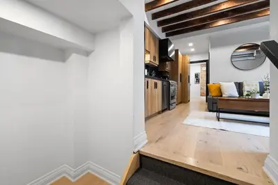 a living room with a couch and a kitchen at Modern Parkdale Getaway 1-Bedroom Parking in Toronto