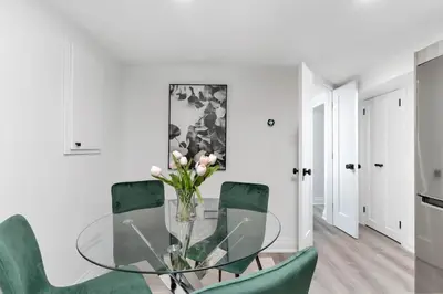 a dining room with a glass table and green chairs at Modern 1-BR Condo with Parking in Downtown Toronto in Toronto
