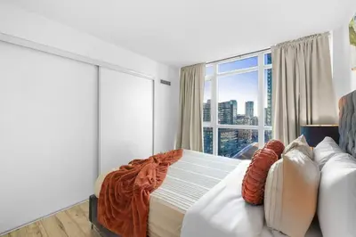 a bedroom with a bed and a large window at Modern Lakefront Esc Stylish 2BR Condo with Patio in Toronto
