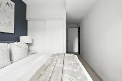 a bedroom with a white bed and a wall at Gorgeous 2BR in Downtown Toronto w City Views in Toronto