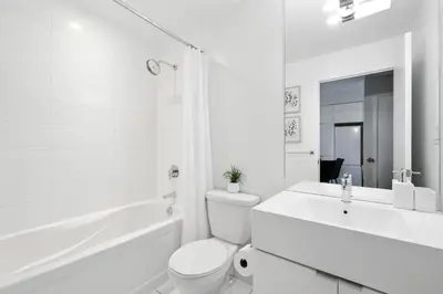 a white bathroom with a toilet and a sink at Gorgeous 2BR in Downtown Toronto w City Views in Toronto