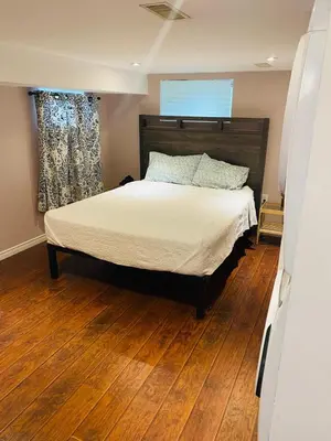 a bedroom with a bed and a wooden floor at Peterborough Cosy Apartment in Peterborough