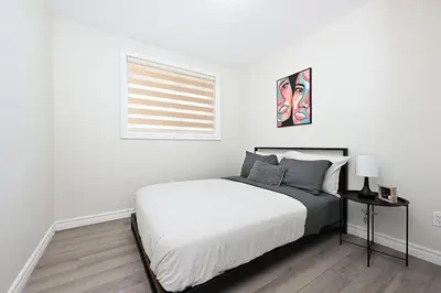 a white bedroom with a bed and a window at The Hamilton Haven in Hamilton
